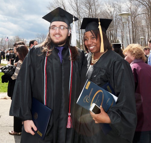 two students wearing graduation gowns and caps